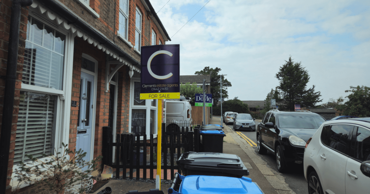 UK terraced houses with a ‘For Sale’ sign on the street — representing the UK property market and landlord opportunities.